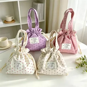 Primer plano de bolsos de lona con cordón y estampado de estrellas, costuras limpias y asas prácticas.