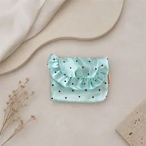 Mint green satin coin purse detail showing cute polka dot print and delicate ruffle flap design.