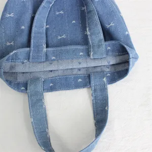 Vista detallada del bolso tote de denim, pequeno bolso de mano con bordados.