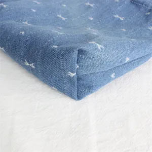 Vista de cerca del fondo del bolso vaquero azul con textura de tela y detalles de costura.