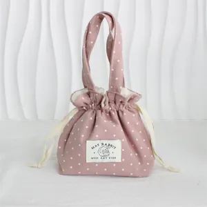 Vista muy detallada y cercana del encantador bolso con cordón de lona rosa con estrellas.