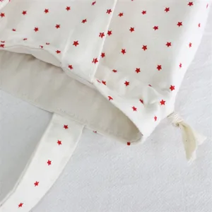 Bolso de almacenamiento con cordón de lona con diseño de estampado de estrellas rojas.