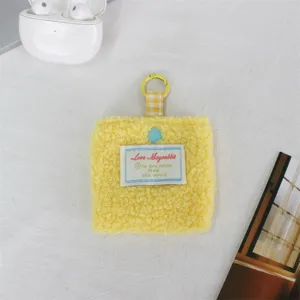Dettaglio borsetta quadrata in peluche giallo, carino mini astuccio auricolari con portachiavi.