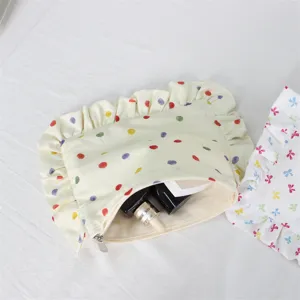 Detailed view of the cute ruffled cosmetic pouch with dots and spacious interior design.
