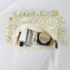 Close-up detail of the cute floral ruffle cosmetic bag showing open interior space with travel bottles.