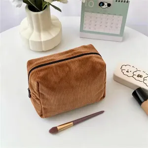 Corduroy cosmetic bag detail view, soft brown zipper pouch for daily travel makeup storage.
