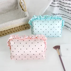 Detailaufnahme der Satin-Kosmetiktasche mit Rüschen und Punkten, weicher Aufbewahrungsbeutel.