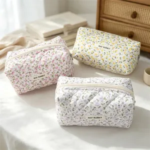 Detailed view of floral quilted cosmetic bag, soft fabric storage and pencil case.