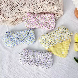 Close-up of cute quilted floral glasses case, soft fabric storage pouch with snap button detail.