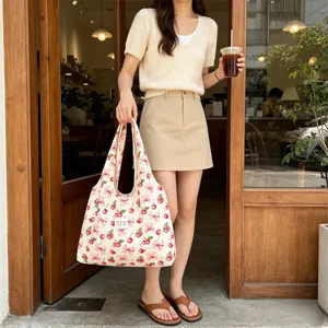 Detailed scene of Korean style cute cherry ribbon printed canvas shoulder bag in daily use.