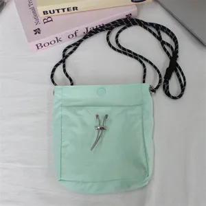 Mentholgrüne Nylon Mini Umhängetasche Handytasche mit Kordelzug und verstellbarem Riemen.