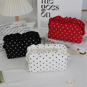 Nahaufnahme von süßen Polka-Dot-Kosmetiktaschen mit Rüschenkanten in Rot, Schwarz und Weiß.
