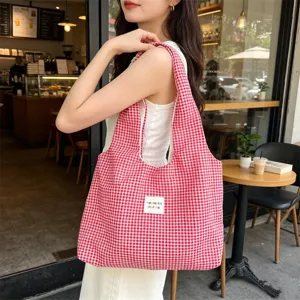 Detail shot of red white plaid canvas tote bag, casual style, perfect for daily commuting use.