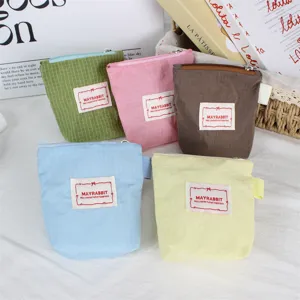 Close-up detail of colorful grid nylon mini zipper coin and lipstick pouches with cute label.
