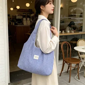Detail shot of blue and white gingham canvas tote bag, casual shoulder bag for daily commuters.