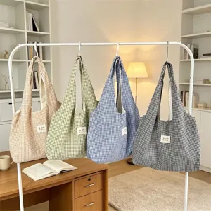 Detailed view of the casual plaid tote bag hanging on a rack, showing large capacity daily use.