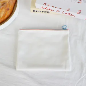 Detail view of minimalist white canvas pencil pouch with blue zipper ring for daily storage.