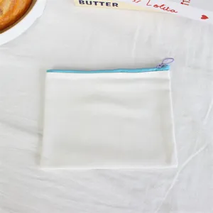 Detail view of simple white canvas zipper pencil pouch featuring blue zip and purple pull.