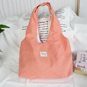 Detailed view of the cozy orange gingham tote bag showcasing soft fabric and cute label.