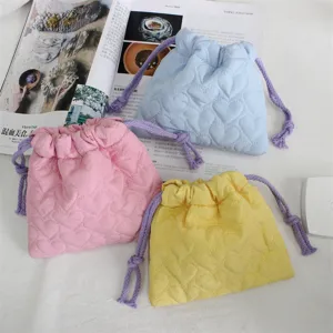 Vue détaillée de la pochette matelassée en cœur, parfaite pour le rangement de bijoux.