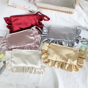 Primer plano detallado de bolsos cosméticos de satén con volantes en varios colores.