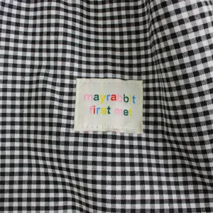 Close-up detail of the casual black and white gingham canvas tote bag with cute label.