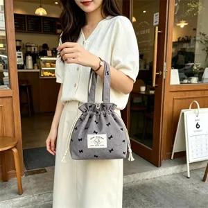 Sac à main cordon en toile grise avec jolis imprimés nœuds noirs, fourre-tout quotidien portable.
