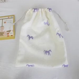 White fabric drawstring pouch with cute purple embroidered horse pattern detail view
