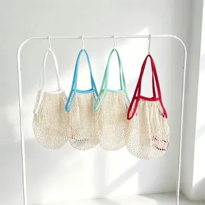 Detailaufnahme von bunten gewebten Netz-Einkaufstaschen am Ständer für den Alltag.
