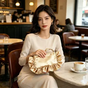 Detalle de bolso de mano de satén dorado con volantes, bolso de noche plisado chic mujer.