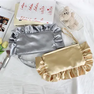 Elegante bolso de mano de satén con volantes, neceser de maquillaje en plata y oro.
