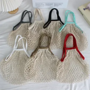 Detailansicht von gewebten Netztaschen mit bunten Griffen für den täglichen Einkauf.