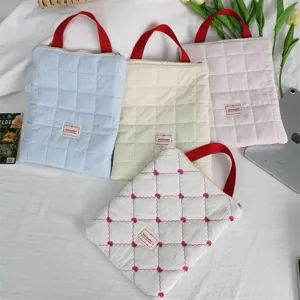 Quilted laptop sleeve with red handles, soft padded tablet storage bag for travel and office use.