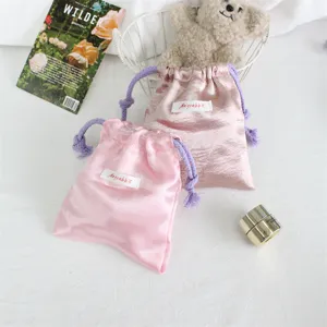 Fluwelen trekkoord zakje detail met glad roze satin stof en delicate paarse koorden.
