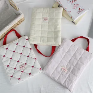 Quilted laptop sleeve with red handle, soft protective tablet storage bag for travel and daily.