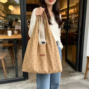 Detailed view of the vintage brown corduroy polka dot tote bag, showing fabric texture.