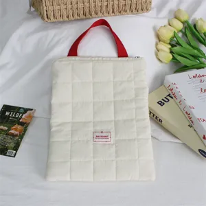 Quilted laptop sleeve with red handle, soft portable tablet protective storage bag for travel.