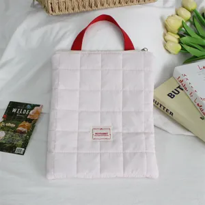 Pink quilted laptop sleeve with red handle, soft protective bag for tablet and travel.