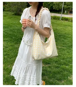 Yellow polka dot shoulder bag detail view, soft fabric hobo bag with adjustable strap.