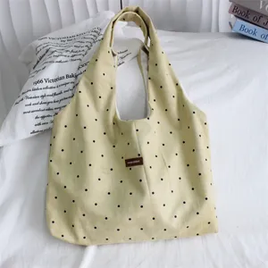 Yellow polka dot suede tote bag detail, stylish and spacious daily commuting shoulder bag.