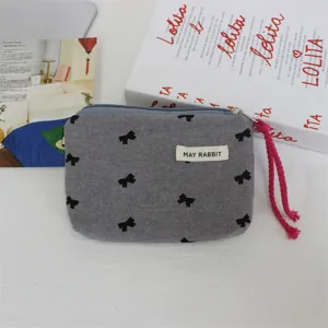 Graue Stoff-Münzbörse mit schwarzem Schleifen-Druck und rosa Kordel-Detail für den Alltag