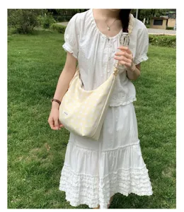 Yellow polka dot shoulder bag detail scene shot, casual fabric hobo bag daily wear design.
