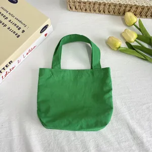 Green nylon mini tote bag detail, lightweight waterproof fabric, compact design for daily use.