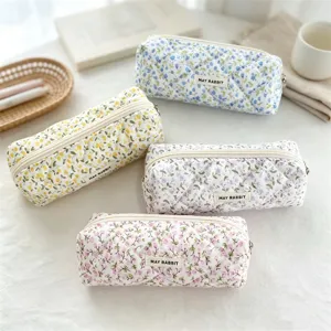 Detailed view of cute quilted floral pencil case, soft fabric makeup pouch storage bag.