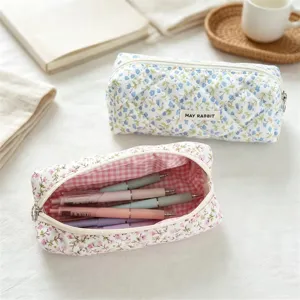Detailed view of quilted floral pencil case on cozy desk, showing fabric texture and interior.
