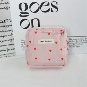 Roze gewatteerde cosmetische etui detail, schattig rood hartjespatroon, handige ritsluiting.