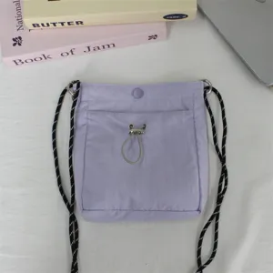 Kleine Nylon Umhängetasche in Pastelllila mit Kordelzugtasche vorne und schicken Gurten.