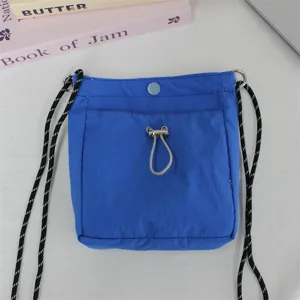 Detailaufnahme der leuchtend blauen Nylon Mini Umhängetasche mit robustem Gurt und praktischer Tasche vorn.