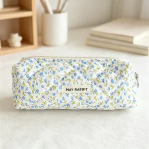 Quilted floral pencil case detail, blue pattern fabric makeup bag with zipper closure.
