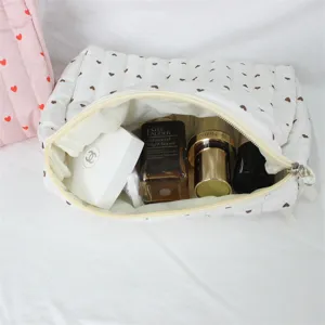 Gedetailleerd overzicht van witte gewatteerde cosmetische tas met hartjes en veel ruimte.